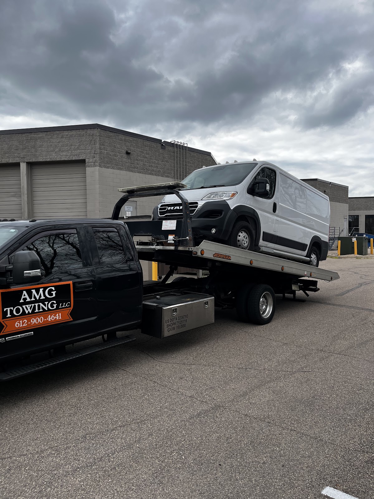 AMG Towing LLC flatbed transporting a van
