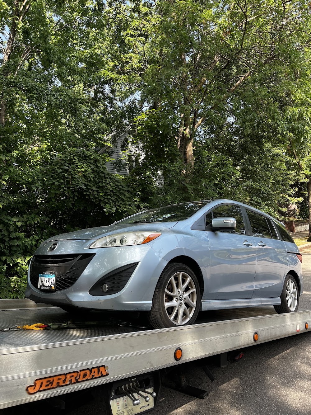 Minivan secured on an AMG Towing LLC flatbed tow truck